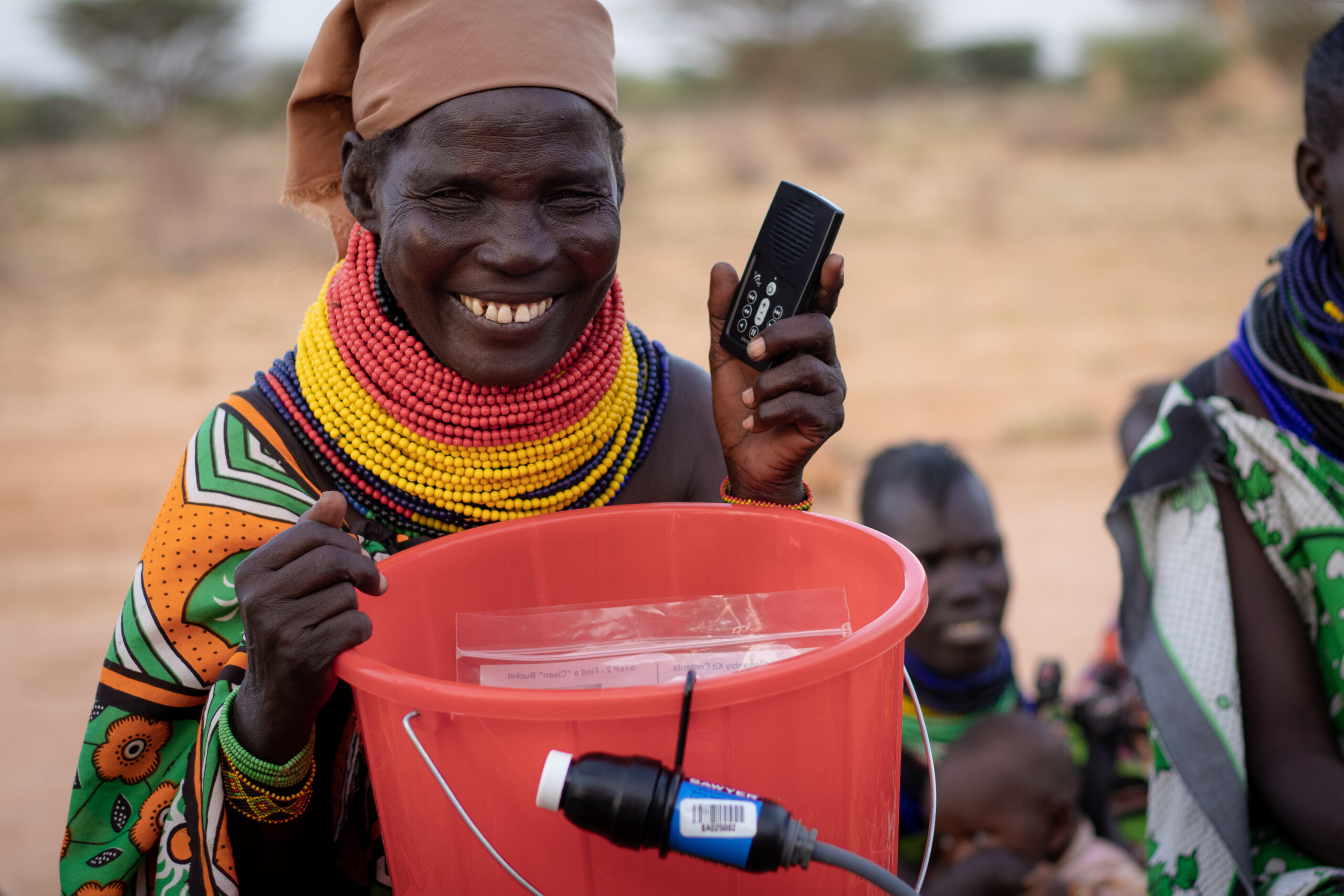 Tribesperson holds a MegaVoice Audio Bible and a water filtration system