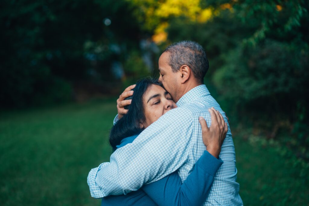 A man and a woman embrace with their eyes closed.
